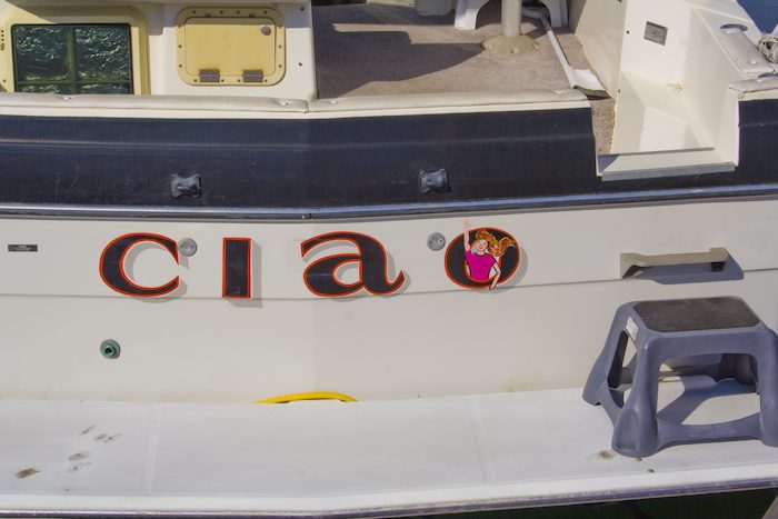 boat named Ciao with person waving