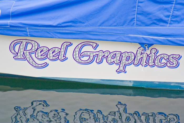 boat named Reel Grphics in 3d font